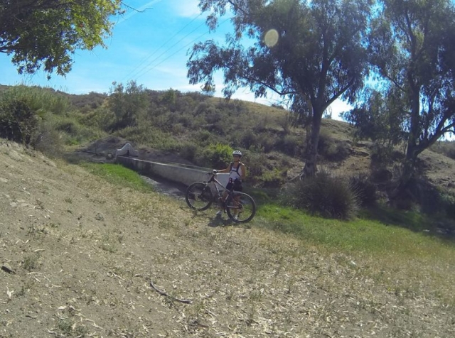 mujer con una bici en un paraje natural